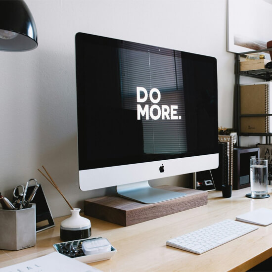 Dev Tech Solutions | One of our Insight Article images showing a desktop Mac with a screensaver stating 'Do More'