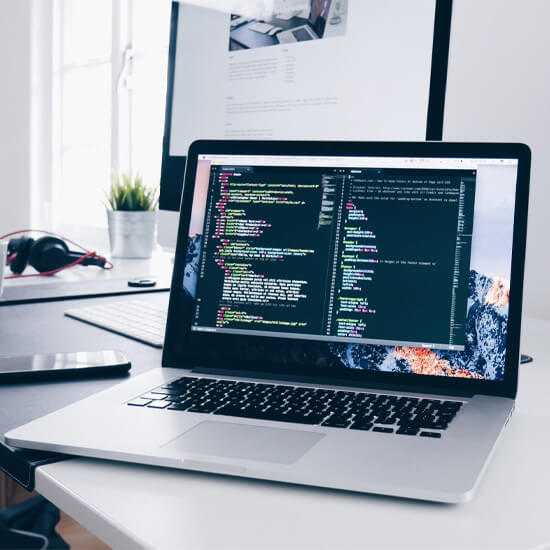 Dev Tech Solutions | One of our Insight Article images showing a Macbook with a range of code on the screen